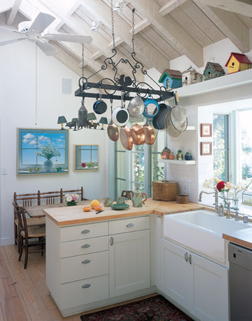 Skylights flood the kitchen with natural light. Rigid insulation was installed between the exposed wood ceiling and the metal roofing, and ceiling fans minimize the need for air conditioning.